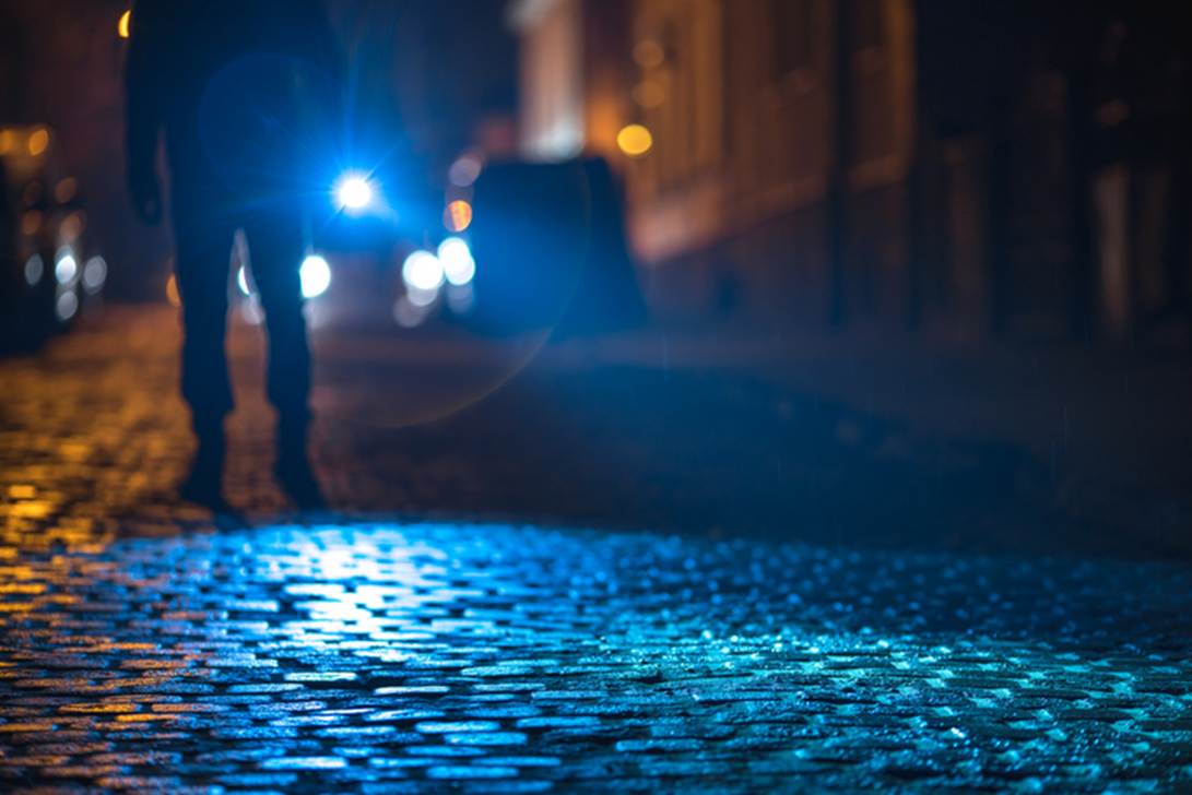 A person walking on a cobblestone street at night
AI-generated content may be incorrect.